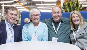 Group of four executive leaders sitting at a table in an office.