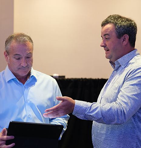 Two men having a discussion while consulting a tablet